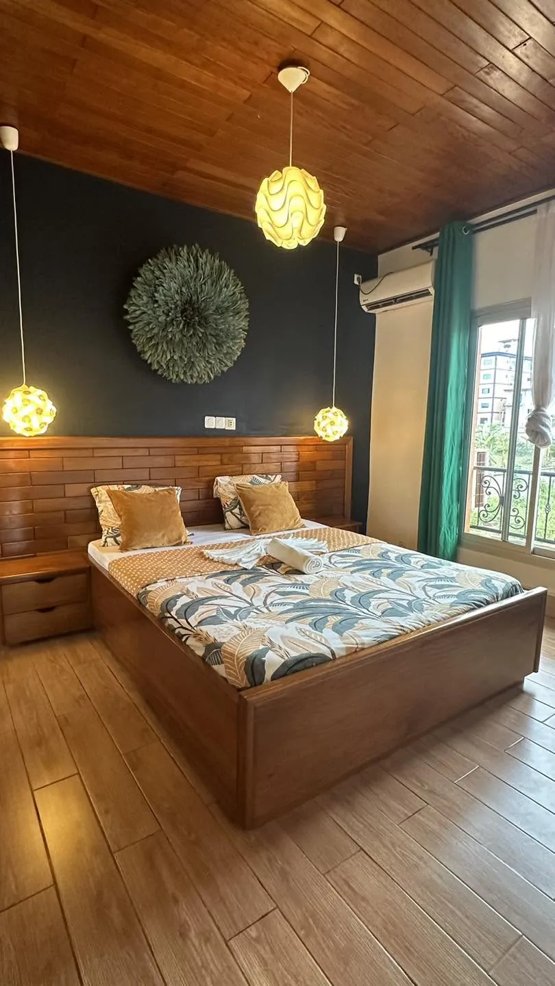 Chambre chaleureuse au plafond en bois, lit double et suspensions