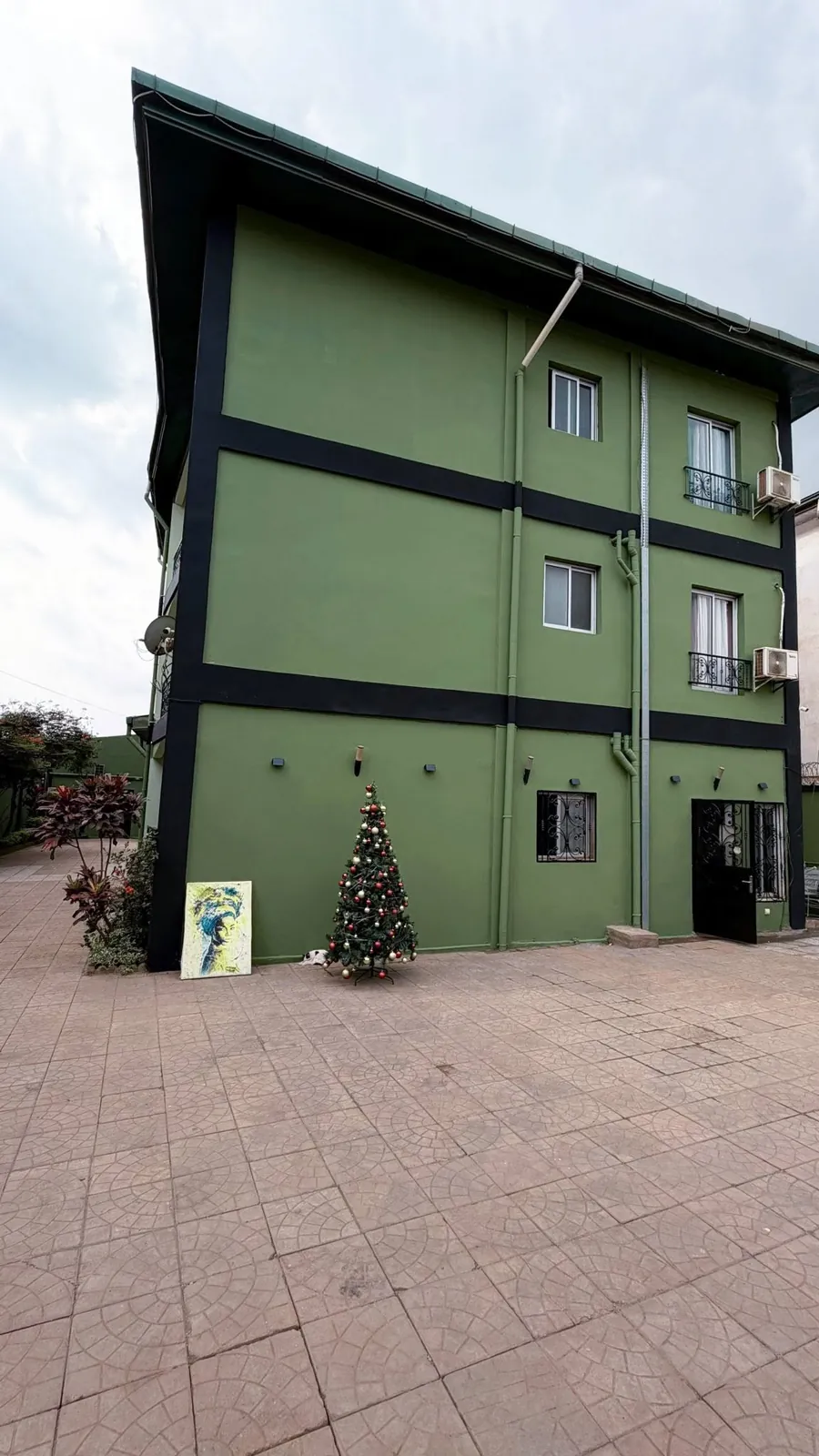 La façade verte de la résidence Nandy's Home et sa cour pavée