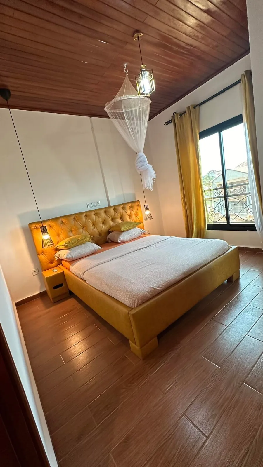 Chambre avec grand lit, moustiquaire et fenêtre lumineuse
